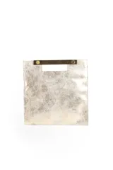 Cartera plateada tipo sobre con asa rígida dorada.