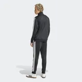 Conjunto deportivo Adidas Dayready de color negro con las clásicas tres tiras blancas en mangas y laterales del pantalón, confeccionado en suave tejido tricot de poliéster reciclado. Incluye campera con cierre frontal y cuello alto, y pantalón con cintura elástica ajustable.