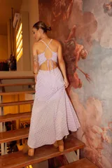 Vestido largo de crepé color lila con estampado de lunares brillantes. Presenta escote corazón, tirantes finos y falda con frunces laterales y tajo profundo.