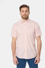 Camisa lisa de manga corta color rosado, con cuello clásico, cierre de botones frontal y un bolsillo en el pecho. Confeccionada 100% en algodón.