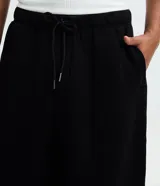 Pantalón baggy masculino de corte holgado, color beige, confeccionado en algodón con felpa. Posee cintura elástica con cordón ajustable, bolsillos delanteros y bajo con regulador por elástico.
