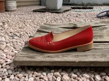 Mocasines de cuero plateado con acabado texturado, diseño clásico con costuras visibles y vira de suela natural cosida. Cuenta con taco plano de 2 cm y plantilla anatómica.