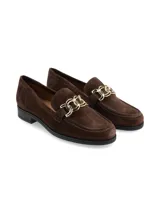 Mocasines de gamuza color marrón, con herraje metálico dorado en el empeine y suela plana con tacón bajo.