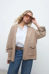 Kimono de tejido de punto en color beige, con diseño abierto al frente, mangas tres cuartos y bolsillos aplicados con ribete oscuro.