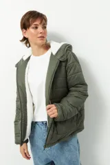Campera puffer verde militar de nylon con capucha y peluche blanco en el interior.