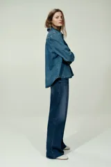 Jean wide leg de tiro alto en denim de algodón con ligero stretch, cinco bolsillos, lavado azul con efecto deslavado y terminación desmechada en el bajo.