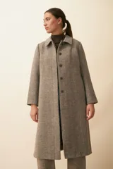 Tapado con cuello solapa y corte recto, color gris. Cierre frontal con botones ocultos, tajos laterales y bolsillos escondidos en corte lateral. Con forro. Tela 100% lana fina sin teñir, diseñada exclusivamente por Don Baez. Hecha 100% en Uruguay.