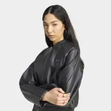 Campera Adidas estilo bomber de efecto piel color negro, de corte holgado, con cierre frontal de cremallera y diseño urbano.