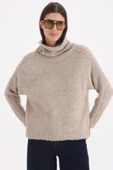 Sweater polera de tejido de punto combinado, con cuello alto, manga larga y diseño holgado.