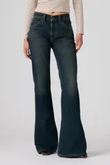 Jeans de denim azul oscuro con lavado vintage, tiro alto y corte acampanado.