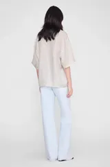 Camisa de corte relajado confeccionada en tejido ligero con estampado animal print en tonos neutros. Presenta cuello clásico, cierre frontal con botones, mangas cortas y bajo recto.