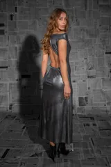 Vestido largo plateado de fiesta, confeccionado en tejido fluido con sutiles destellos. Presenta escote barco y espalda descubierta.