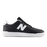 Championes New Balance modelo 80, color negro con detalles en blanco. Presentan el logo "N" en los laterales, suela blanca y perforaciones en la puntera.