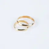 Par de alianzas bombé en oro 18k de diseño clásico, con acabado pulido y una de ellas engastada con un pequeño diamante central.