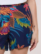 Short de calce relajado de la marca Elie Tahari, con estampado floral tropical multicolor sobre base azul marino. Presenta cintura alta con pretina lisa en el frente y elástico posterior, con perneras holgadas de corte recto.