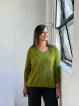 Sweater de punto color verde pistacho, con escote en V, mangas largas y corte holgado.