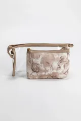Pack de dos necessaires, uno transparente y otro con estampa floral en tonos beige, ambos con cierre superior y detalles en color beige.