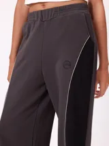 Babucha de corte holgado en color beige con paneles laterales en color fucsia y vivos blancos. Presenta cintura elástica y logo bordado en la parte superior.