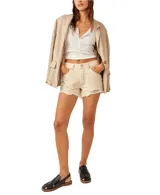 Short de denim color beige, de tiro medio con bolsillos delanteros y traseros. Presenta roturas sutiles en la parte delantera y dobladillo desmechado.