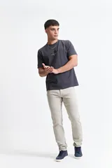 Remera gris oscuro de manga corta con cuello redondo y estampado pequeño en el pecho.