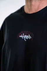 Remera oversize de algodón elastizado en color negro, con diseño gráfico estampado en la espalda que representa un arco gótico con detalles en rojo y texto.