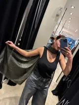 Pashmina de tejido ligero con acabado metalizado en tono oscuro, con bordes desflecados.