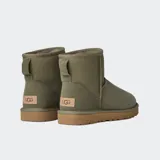 Botas de caña baja UGG, color negro, confeccionadas en piel de oveja con forro interior de lana suave y suela de goma resistente.