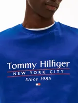 Remera azul de algodón con cuello redondo y logo de Tommy Hilfiger New York City estampado en el pecho.