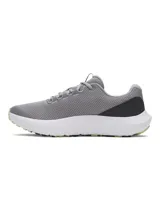 Championes de running Under Armour Charged Surge 4, color gris con detalles en verde lima y blanco. Presentan una parte superior de malla transpirable con refuerzos sintéticos, entresuela Charged Cushioning para mayor amortiguación y suela de goma resistente.