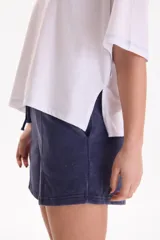 Remera de algodón blanca de manga corta, diseño cropped y calce cómodo. Cuenta con tajos laterales y costuras a contratono en color celeste.