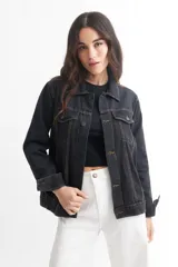 Campera de jean celeste con cuello clásico, cierre frontal con botones metálicos negros, bolsillos con solapa abotonada en el pecho y mangas largas con puños abotonados.
