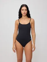 Malla entera color negro con breteles finos y escote redondo. Presenta un diseño minimalista con logo de la marca bordado en el lateral.