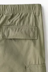 Pantalón cargo de corte relajado confeccionado en lona de algodón. Presenta bolsillos laterales con solapa, bolsillos al bies y bolsillos traseros. Incluye pliegues reforzados en las rodillas y cierre con botón.