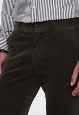 Pantalón de pana gris con corte slim fit, bolsillos laterales y traseros, y cinturón trenzado verde.