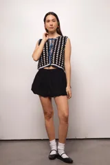 Chaleco tejido a crochet con hilado 100% algodón, con diseño a cuadros en azul y blanco, y terminaciones en verde.