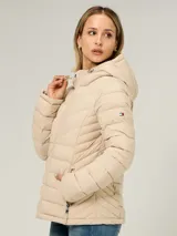 Campera ligera acolchada Tommy Hilfiger, color beige, con diseño de costuras horizontales y en V, cierre frontal de cremallera, capucha ajustable con cordones y bolsillos laterales con cierre.