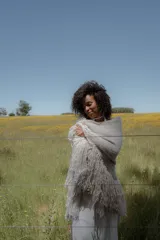 Ruana triangular color crudo, tejida en bouclé de lana y acrílico.