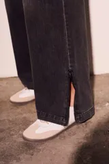 Pantalón de jean negro con efecto desgastado, corte wide leg y cierre con cremallera en los tobillos.