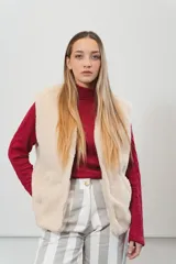 Chaleco color crema con textura de piel sintética, sin mangas y con forro interno.