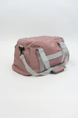 Bolso deportivo color rosa con detalles en beige y gris. Tiene doble asa de mano y correa de hombro ajustable. Cuenta con dos bolsillos frontales con cierre y logo de la marca en la esquina inferior derecha.