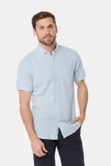 Camisa de lino de manga corta con estampado a cuadros en tonos celestes y blancos, cuello con botones y bolsillo ojal en el pecho.