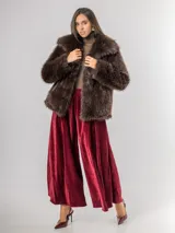 Pantalón tipo palazzo de corte oversized, confeccionado en tela con textura aterciopelada en color negro. Presenta cintura alta con pinzas, bolsillos laterales y un cinturón ancho integrado con hebilla al tono.