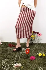 Top strapless de microtul con estampado de lunares amarillos sobre fondo marrón. Presenta un diseño versátil con cordones laterales ajustables que permiten modificar su largo y ajuste.