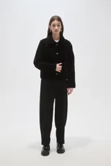 Chaqueta de poliéster con diseño capitoneado, cuello tipo camisa, cierre frontal con botones y bolsillos delanteros.