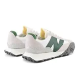 Championes New Balance modelo XC-72, unisex, color blanco con detalles en verde y gris. Capellada de cuero y gamuza, con suela de goma texturizada.