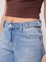 Jean de corte baggy y tiro medio, confeccionado en denim de algodón en tono azul claro con efecto lavado. Presenta diseño de cinco bolsillos, cierre frontal con botón y cremallera, y pernera ancha.