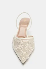 Zapato destalonado con tacón fino, color blanco. Capellada de mesh con bordados florales. Tira trasera elástica y punta fina. Tacón de 6 cm.