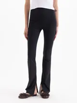 Pantalón Margot de microfibra negra, de tiro alto y silueta ajustada con botamangas acampanadas y tajos laterales.