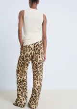 Pantalon de tiro medio con diseño recto y fluido, confeccionado en viscosa con estampado animal print de leopardo. Cuenta con cintura elástica con lazo de ajuste, forro interior y bolsillos laterales.