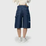 Bermuda de jean estilo baggy, confeccionada en denim de algodón premium con textura rústica. Presenta un diseño de corte amplio, costuras reforzadas en contraste y un bordado distintivo en la parte inferior de la pierna.